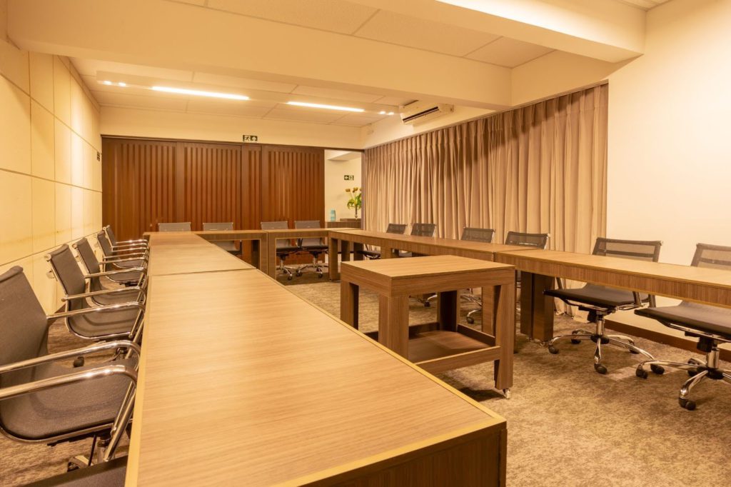  Sala de reunião corporativa com layout em U elegante do Foco Coworking.