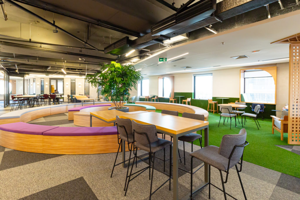 Espaço de convivência com design aberto e mesas compartilhadas do coworking Nébula Catalisadora.
Legenda: Nébula Catalisadora – Itaim Bibi, São Paulo/SP