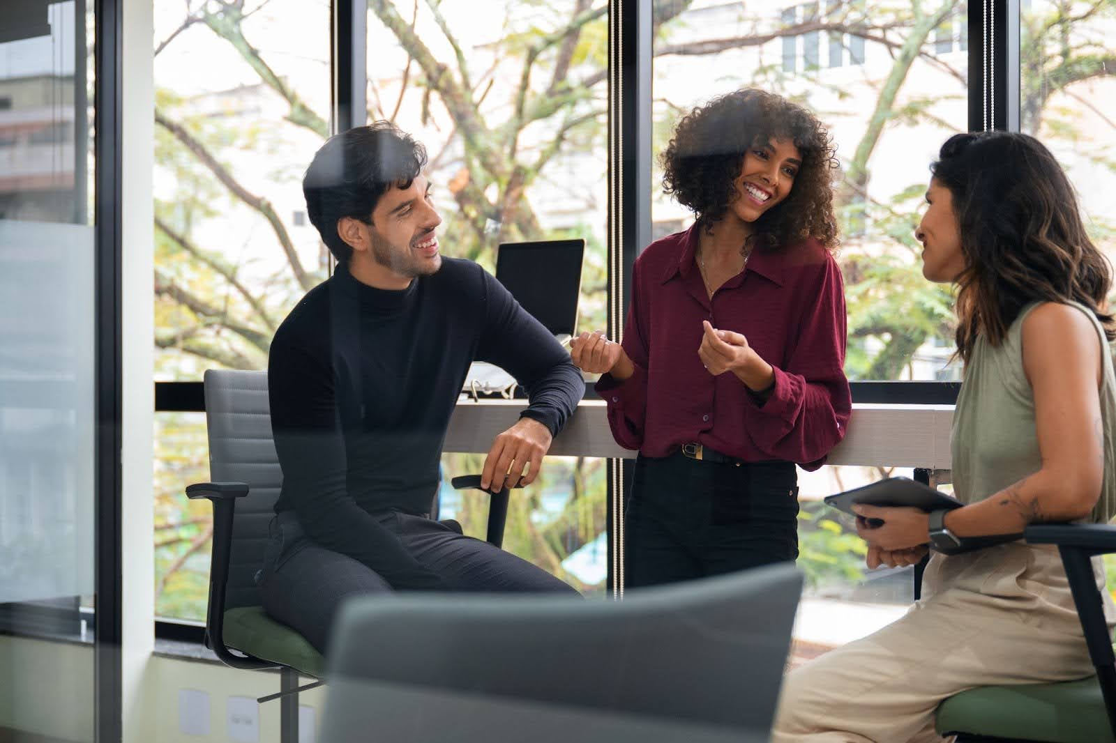 Profissionais fazendo newtworking em uma área de trabalho compartilhada de um coworking.